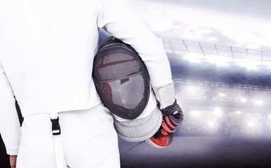 Rear view of swordsman holding fencing mask 