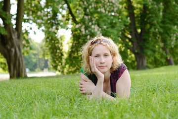 Naklejka na ściany i meble Beautiful young woman resting in the park
