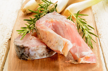 raw carp steak with rosemary and spring onions