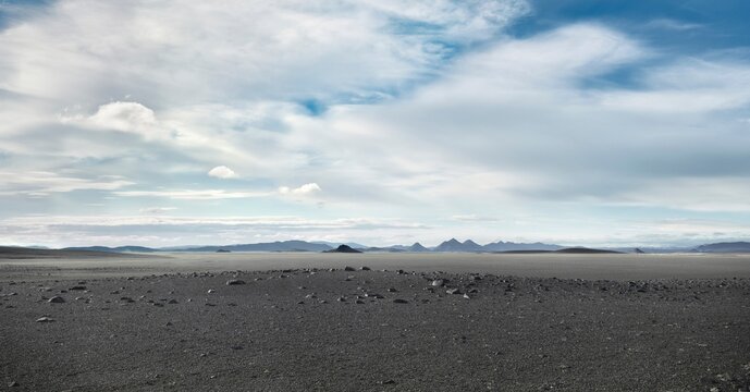 Grey barren landscape under cloudy sky