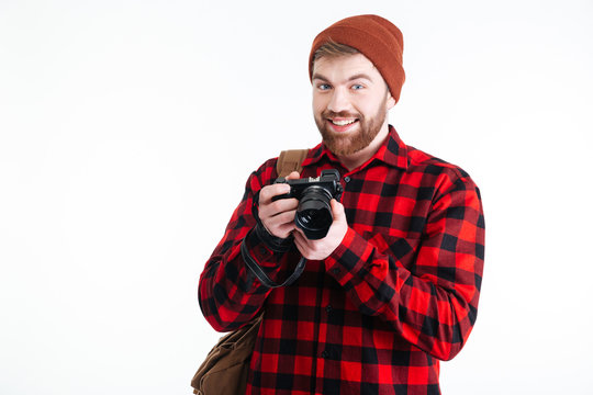 Handsome young man holding digital camera on white background