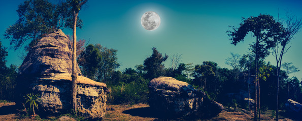Panorama of boulders against beautiful sky and full moon 
