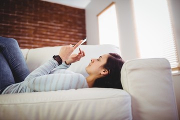 Obraz premium Woman using mobile phone at home