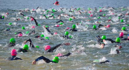 Competitors swimming out into open water at the beginning of Triathlon. 
