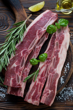 Closeup of fresh uncooked seasoned beef ribs, selective focus