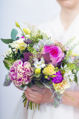 Beautiful colorful wedding bouquet in a hand of a bride