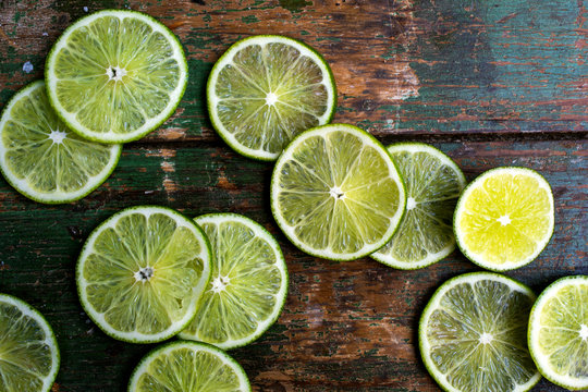 Fototapeta Slices of lime on old wooden surface