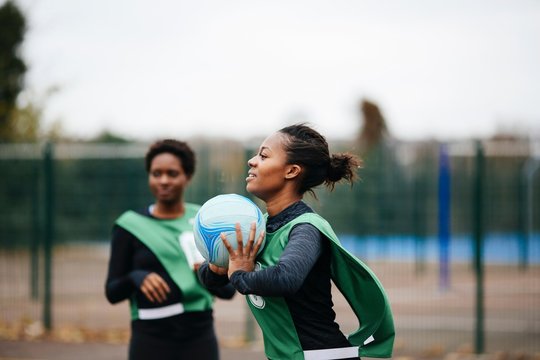 Young adult female netball player at play on netball court