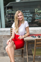 Young beautiful woman with long hair sitting at cafe.