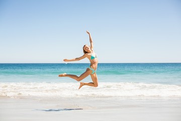 Fototapeta na wymiar Woman jumping on the beach