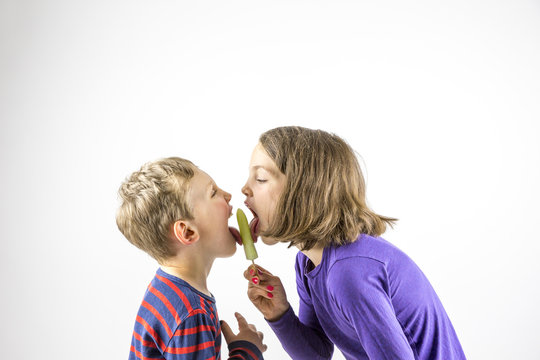 Young boy and girl eating ice cream, sibling love portrait face to face.
