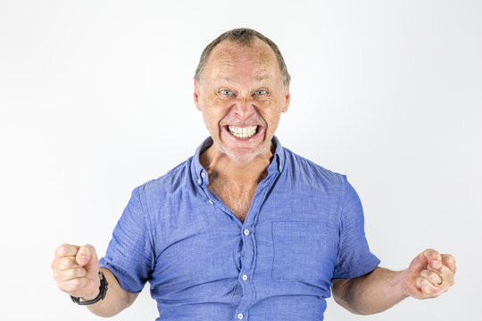 Portrait of angry and furious man in tight blue shirt.