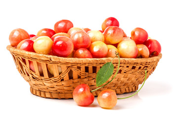 yellow cherries in a wicker basket isolated on white background
