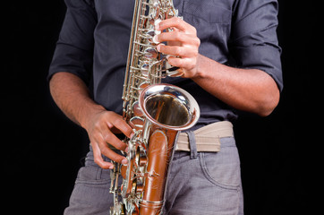Saxophone view with hands playing it, view of the front