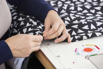 Female Tailor Stitching Fabric At Workbench