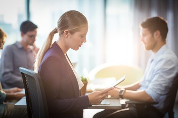 Businesswoman using digital tablet during meeting
