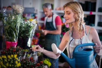 Female florist watering flowers