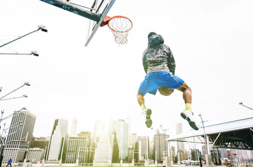 Street basketball player performing an huge rear slam dunk © oneinchpunch