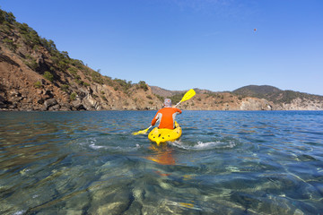 A man traveling by canoe along the coast.