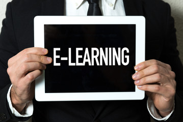 Business man holding tablet with the text: E-Learning
