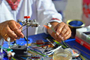the hands of the glassmaker, making figurines of glass
