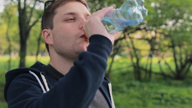 Caucasian man drinking water in the park
