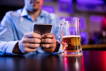 Man using mobile phone at bar counter