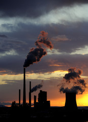 Coal power station in sunset with cloudy sky, industrial landscape