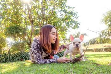 Puppy French Bulldog and Asian girl owner in the Morning sunshine ,lake view Green