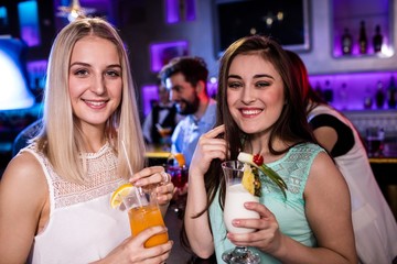 Smiling friends having cocktail at bar counter