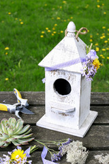 Wooden bird house and spring flowers