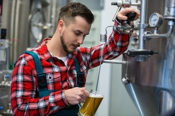 Close-up of brewer testing beer