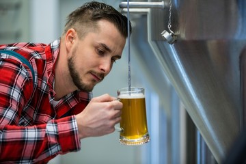 Close-up of brewer testing beer