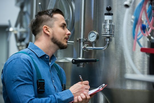 maintenance worker writing on clipboard