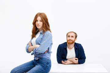 Beautiful redhead girl and boy posing over white background near