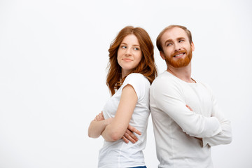 Cheerful redhead girl with boy dressed in white shirt  standing 