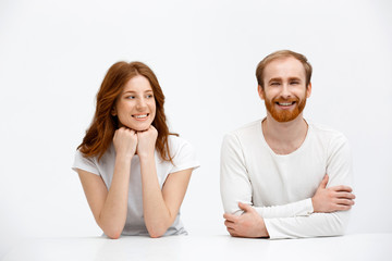 Tenderless redhead girl and boy smile  sitting at white desk