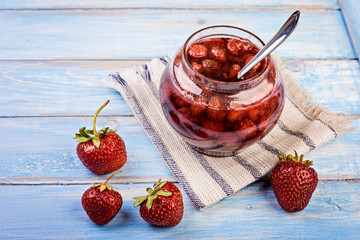Strawberry jelly  in a jar on wooden background