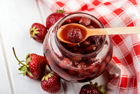 Strawberry jelly  in a jar on wooden background