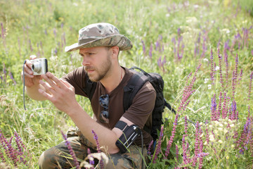 Male tourist shooting nature with compact camera outdoor