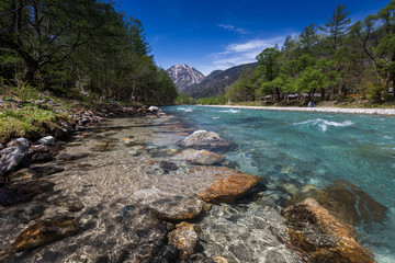 landscape with mountains trees and a river in front