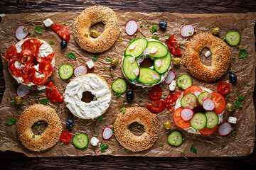 Delicious Bagel sandwiches with soft cheese, chorizo and vegetables - obrazy, fototapety, plakaty