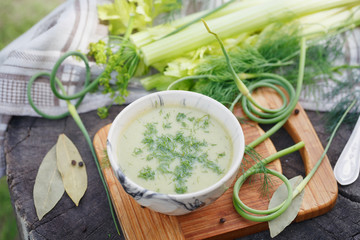 Bowl of green cream soup on wooden table