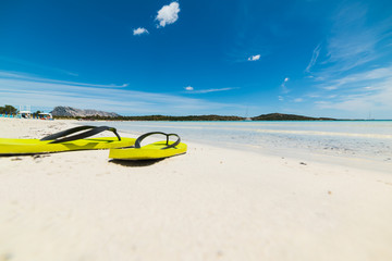 yellow flip flops on the sand