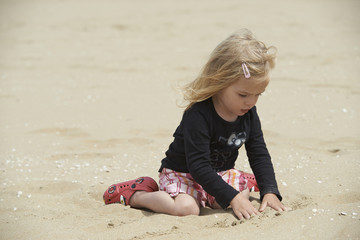 pretty little blond girl have a fun on sandy beach

