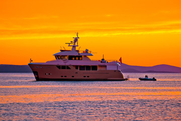 Fototapeta na wymiar Yacht at golden sunset on open sea