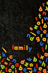he word FAMILY written with colorful magnetic letters on black ground