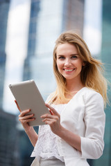 Beautiful woman with electronic tab in the street