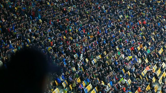Millions of football fans sitting on tribunes and watching match, sporting event