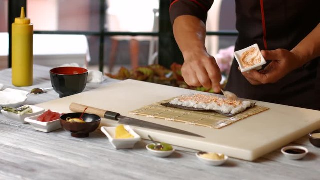 Hands of man cooking sushi. Guy prepares japanese food. Restaurant chef at his workplace. Master of cookery.